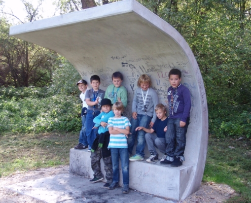 eine Gruppe 8 Kinder, die vor der zu bemalenden Wand stehen